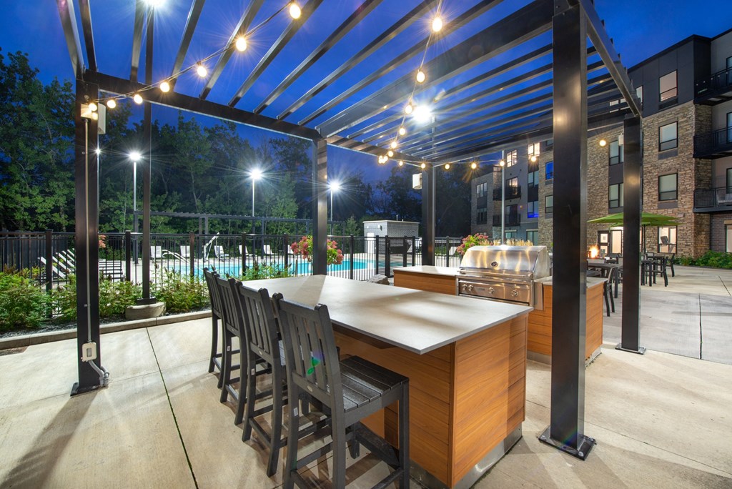 a large outdoor kitchen with a bar and a pool