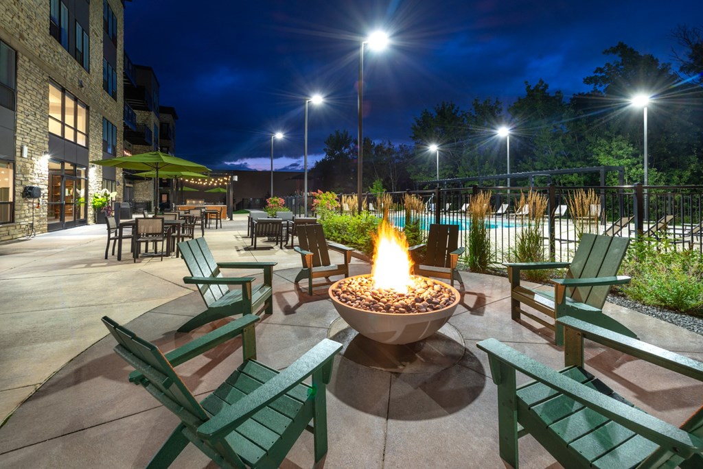 an outdoor patio with a fire pit at night