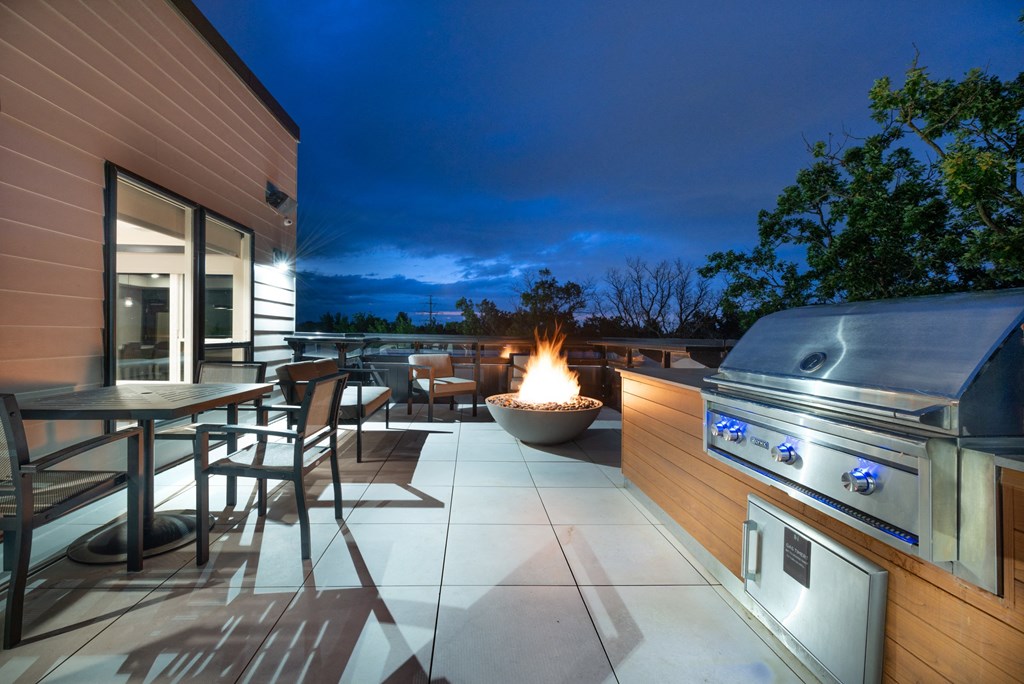 a patio with a fire pit and a barbecue grill