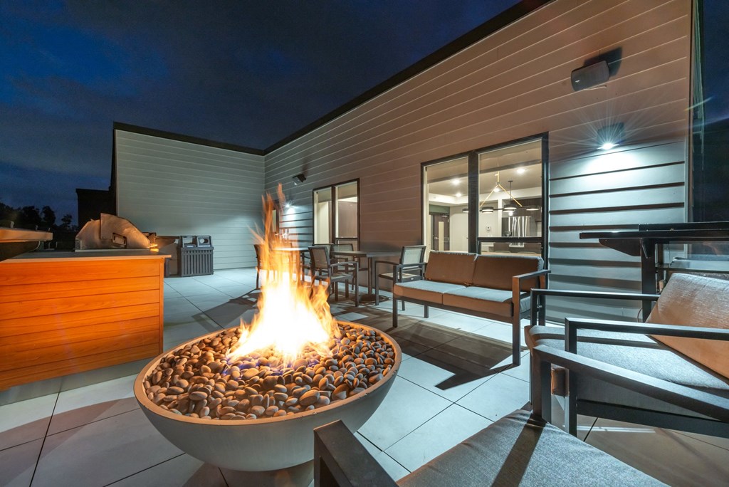 a fire pit on the patio of a home at night
