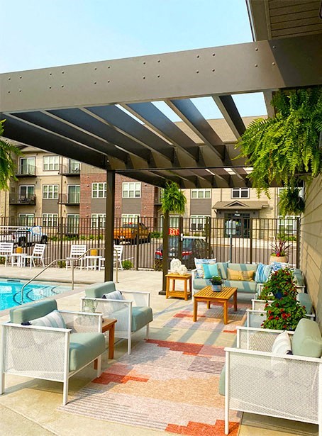 a patio with couches and chairs next to a pool