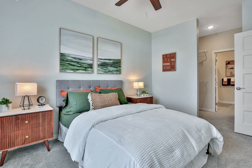 A bedroom with a large bed and a wooden nightstand.