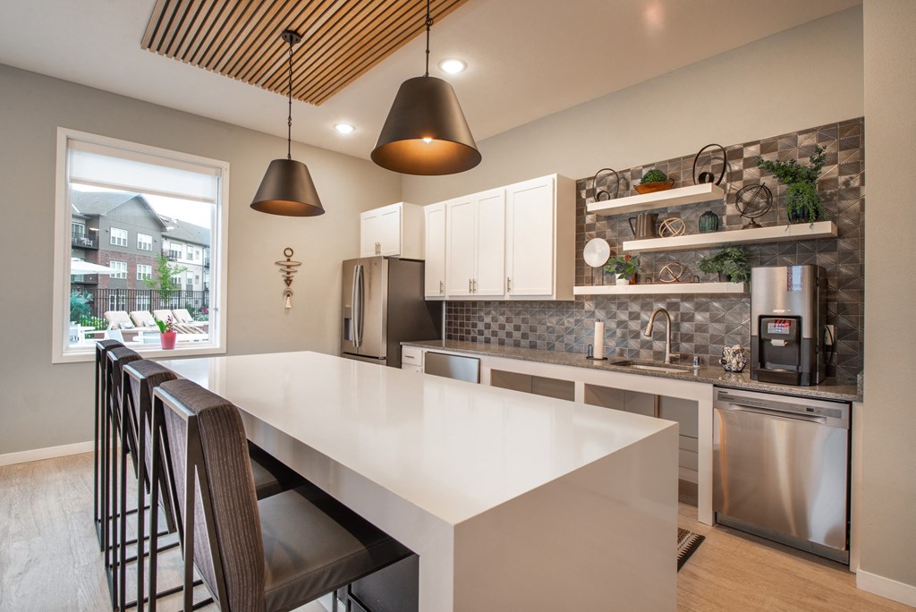 a kitchen with a large white counter top and stainless steel appliances