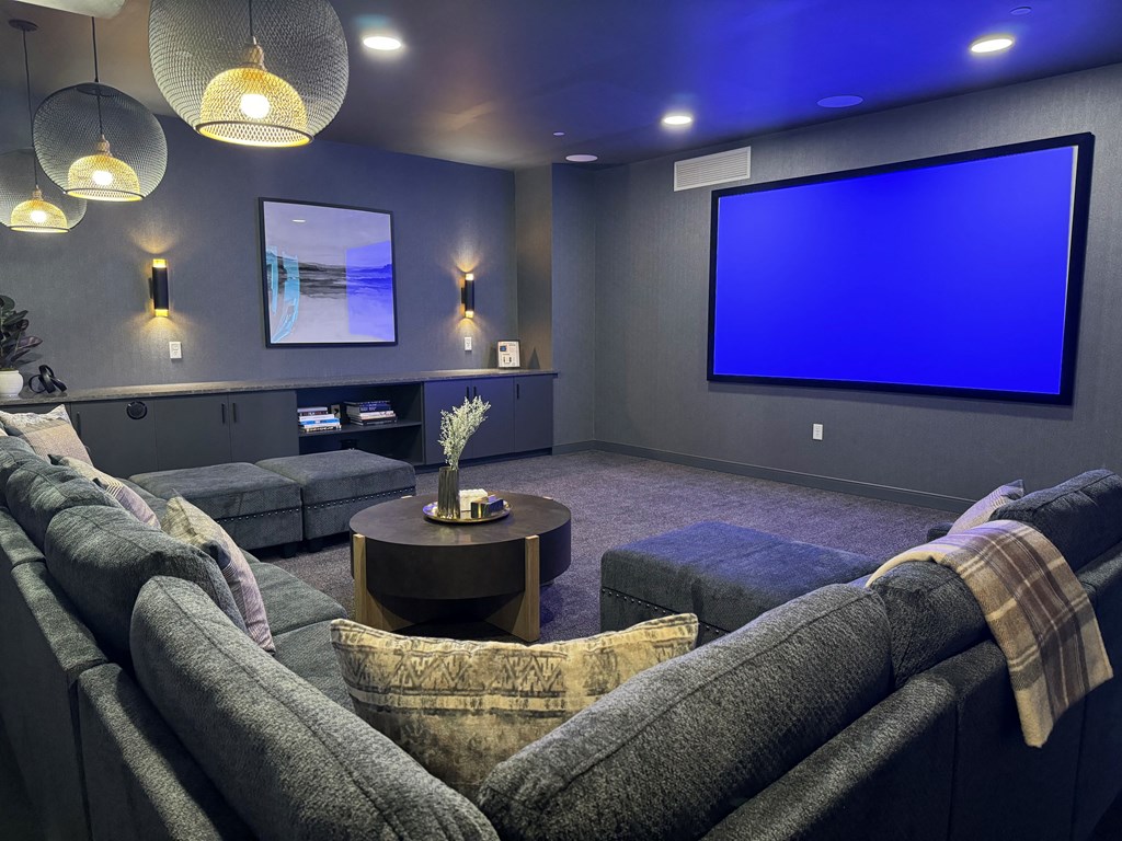 a large screening room with a large screen tv and couches