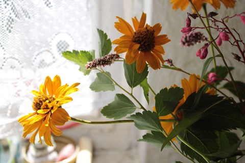A bouquet of flowers in a vase on a windowsill.