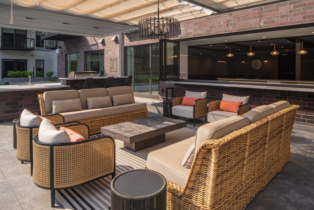 an outdoor patio with rattan furniture and a pool