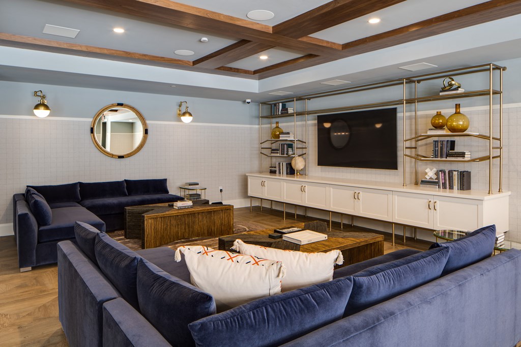 a living room with blue couches and a tv