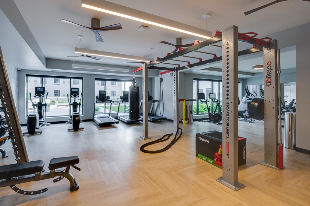 a gym with fitness equipment and windows in a building