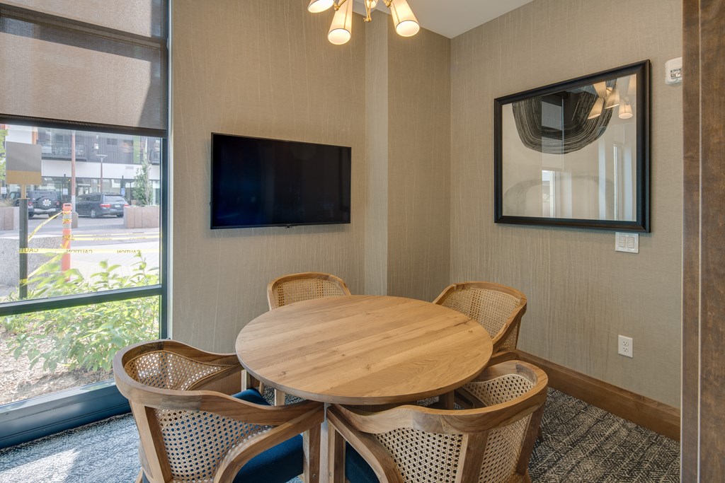 a dining area with a table and chairs and a television
