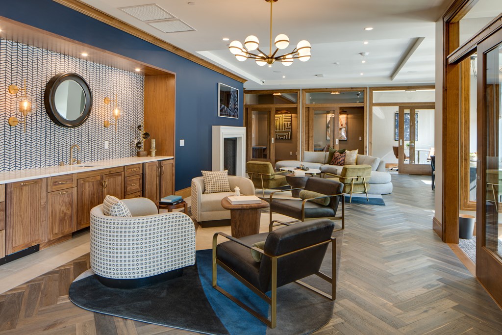 a living room with couches chairs and a bar and a bathroom