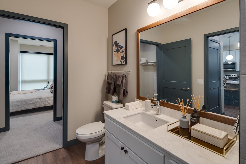 a bathroom with a large mirror and a toilet and a sink