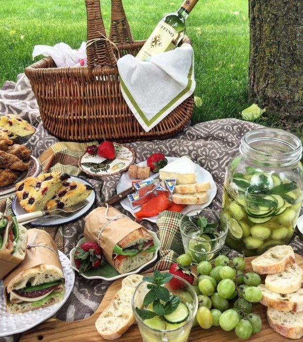 a picnic with grapes and sandwiches and a basket
