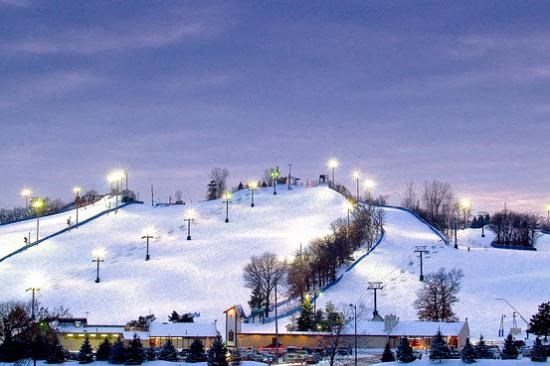 A ski slope is lit up at night.