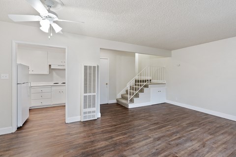 a living room with hardwood floors and white walls