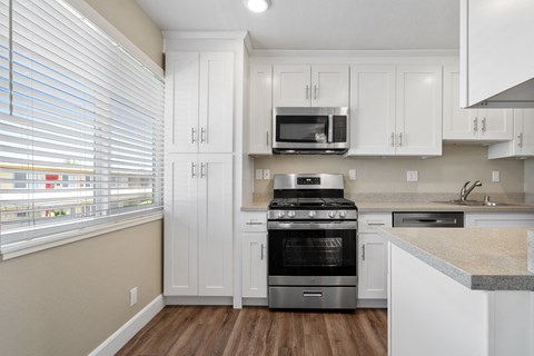 A kitchen with white cabinets and a stainless steel oven.