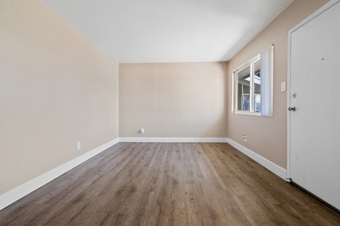 Empty room with wooden floor and white door.