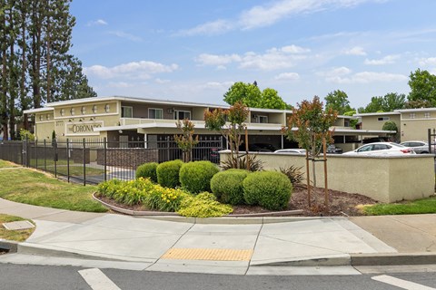a building with a black fence and a sidewalk in front of it