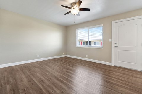 A room with a ceiling fan and a door.