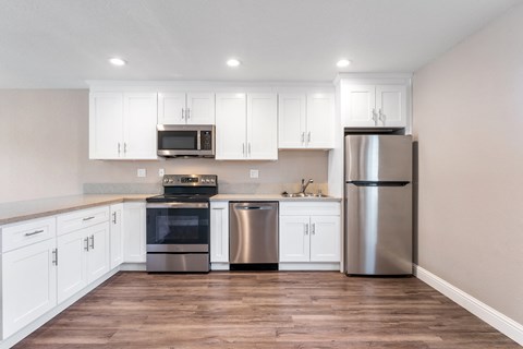 A kitchen with white cabinets and stainless steel appliances.