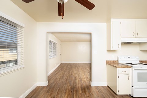 A kitchen with a white stove and wooden floors.