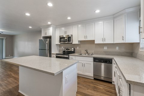 A kitchen with white cabinets and a large island.
