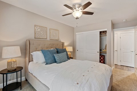 A bedroom with a large bed and a ceiling fan.