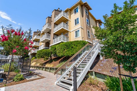 A multi-story residential building with a staircase leading to the entrance.