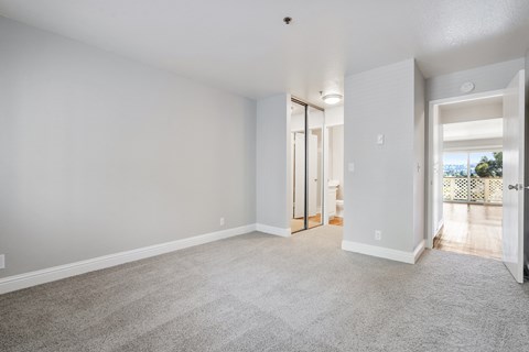 A spacious room with a carpeted floor and white walls.