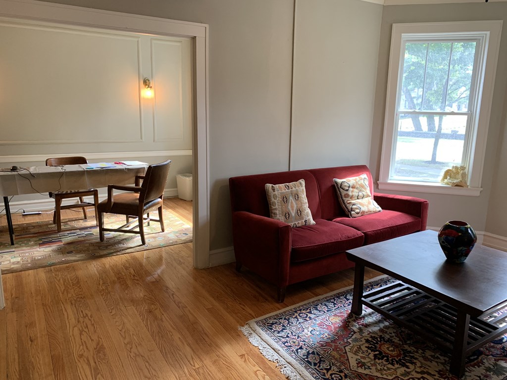 a living room with a red couch and a dining room table