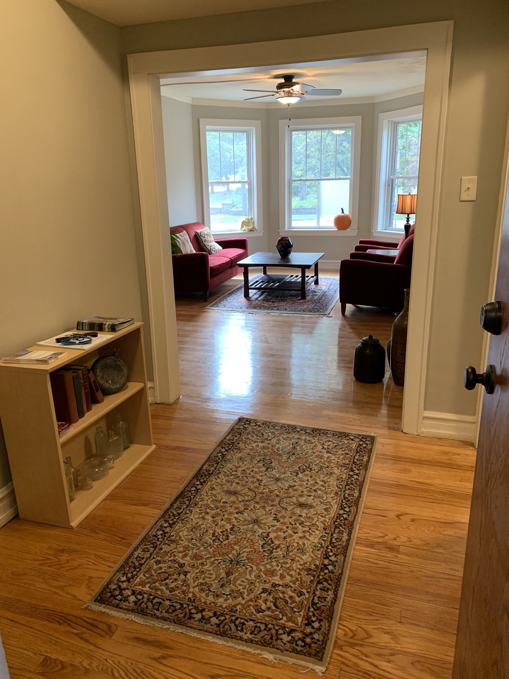 a living room with a rug in the middle of a wood floor