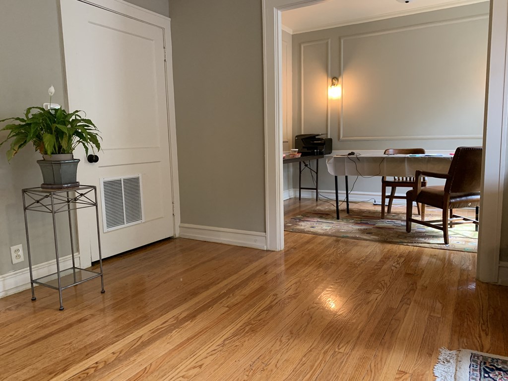 a living room and dining room with a wood floor