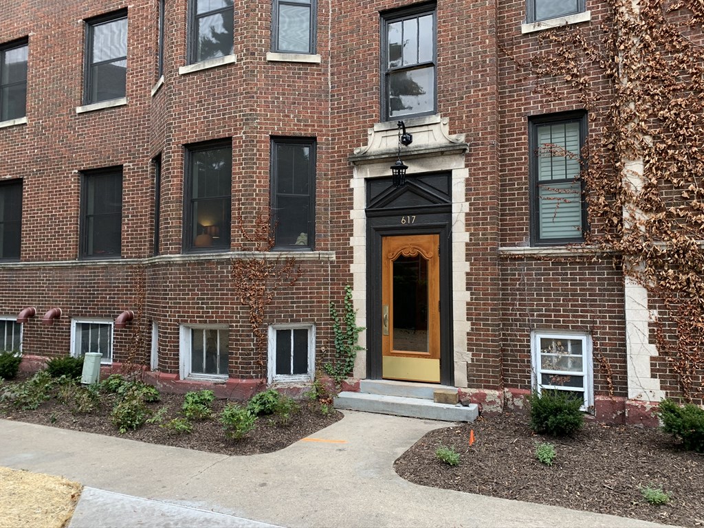 the front of a brick building with a yellow door