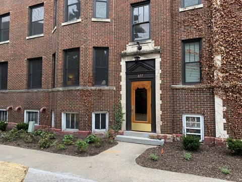 the front of a brick building with a yellow door