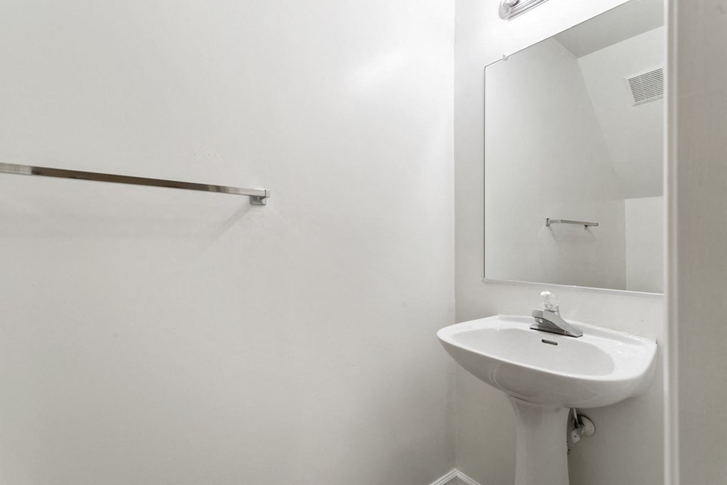 a white bathroom with a sink and a mirror