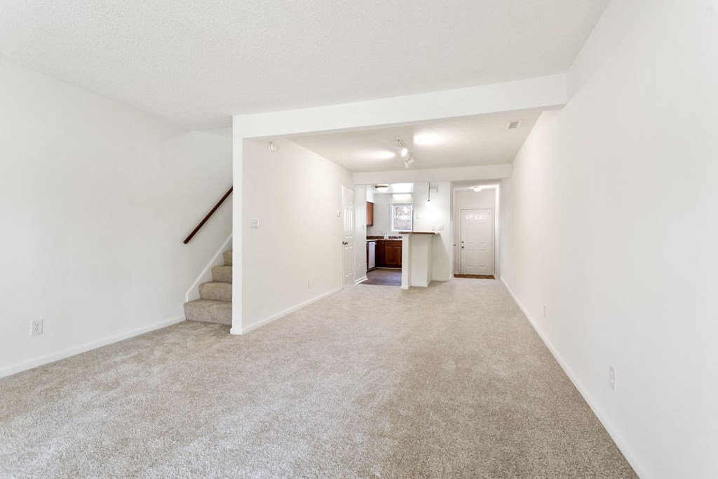 a living room with a carpeted floor and white walls