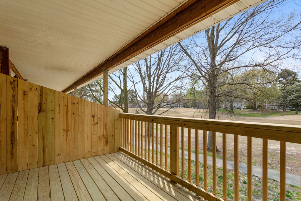 the view from the porch of a cabin with a wooden deck