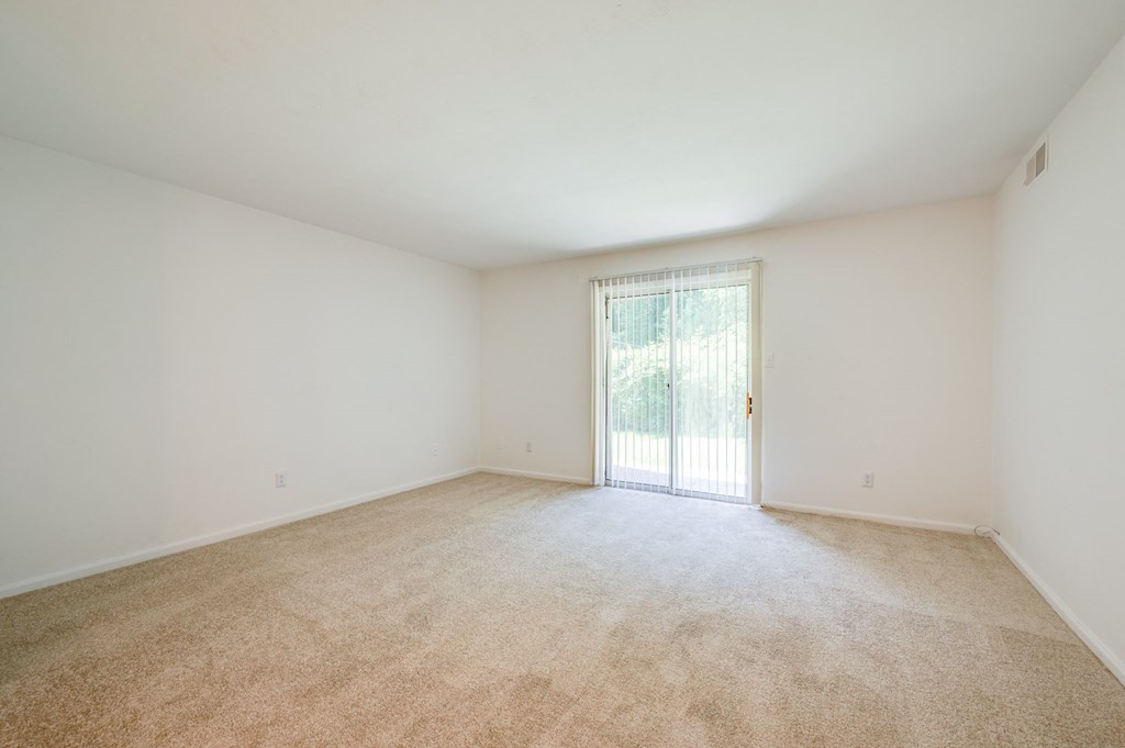 an empty living room with a door to a patio