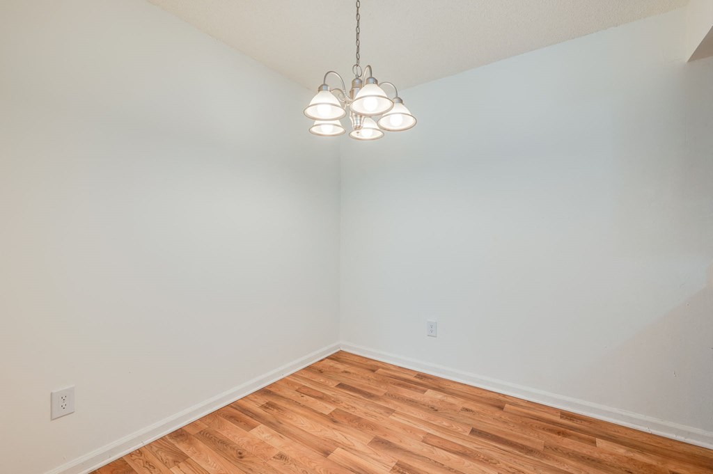 a bedroom with a wood floor and white walls