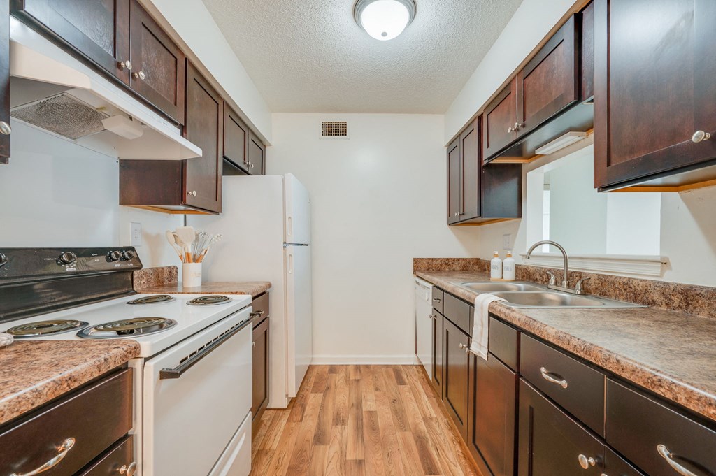 a kitchen with white appliances and brown cabinets