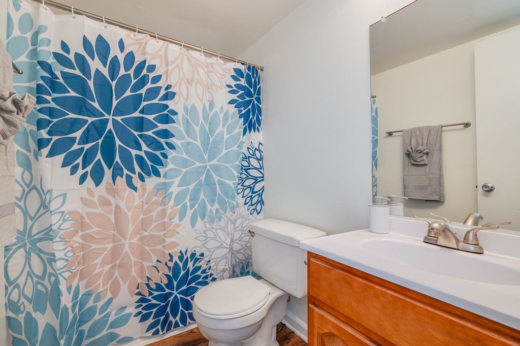 a bathroom with a white toilet and a blue shower curtain