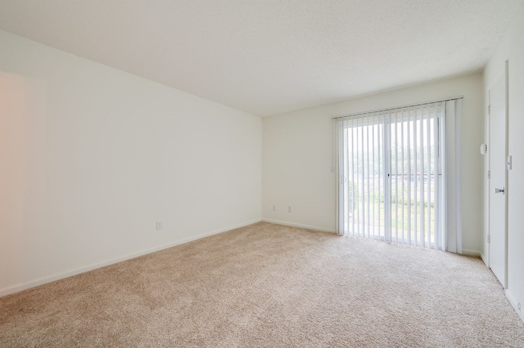 an empty living room with a sliding glass door