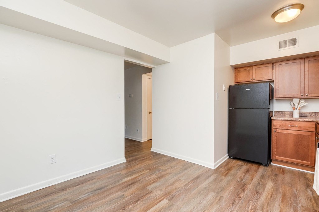 a renovated apartment with a black refrigerator and wooden floors