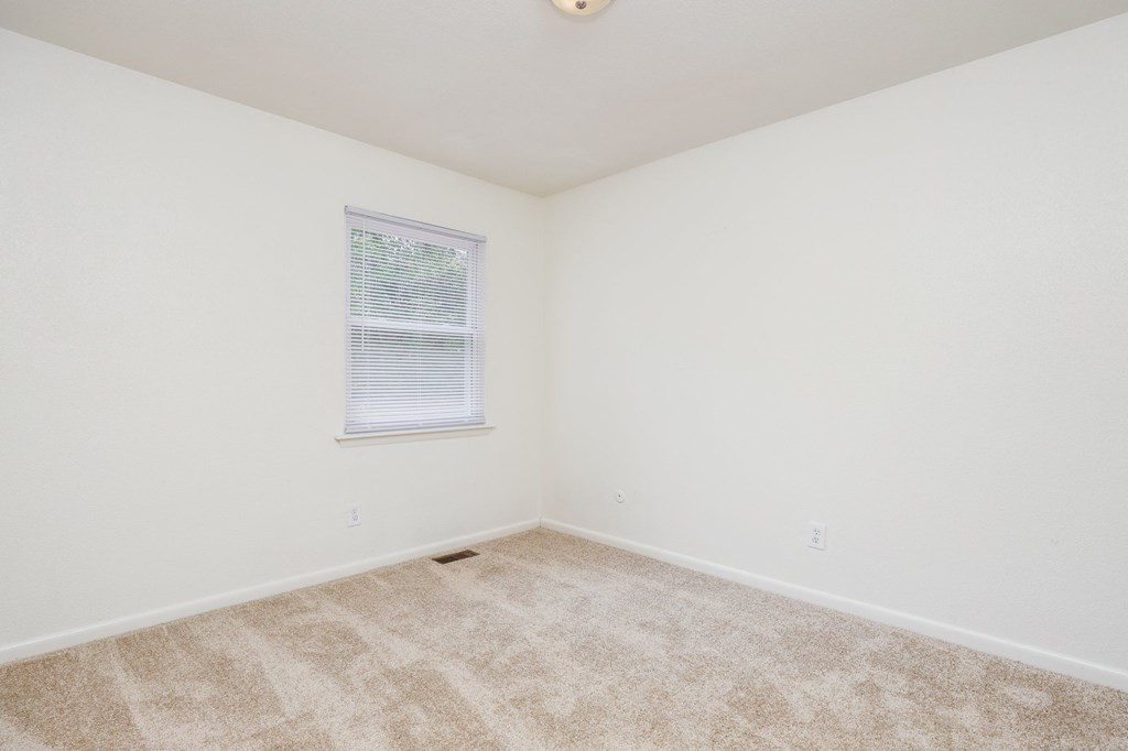 an empty room with carpet and a window