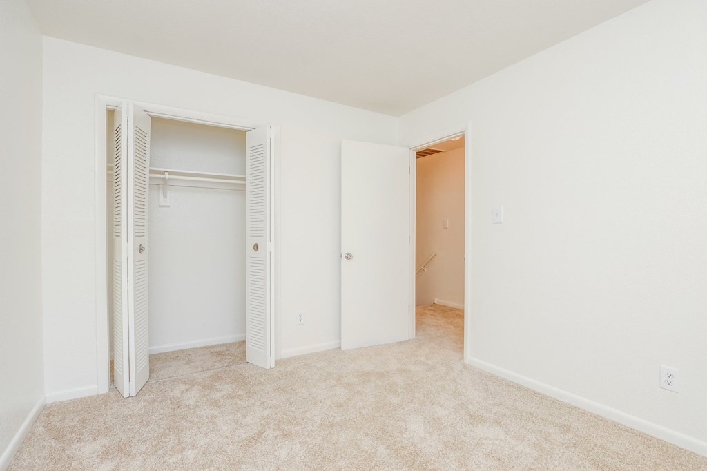 a bedroom with a closet and a hallway with closet doors