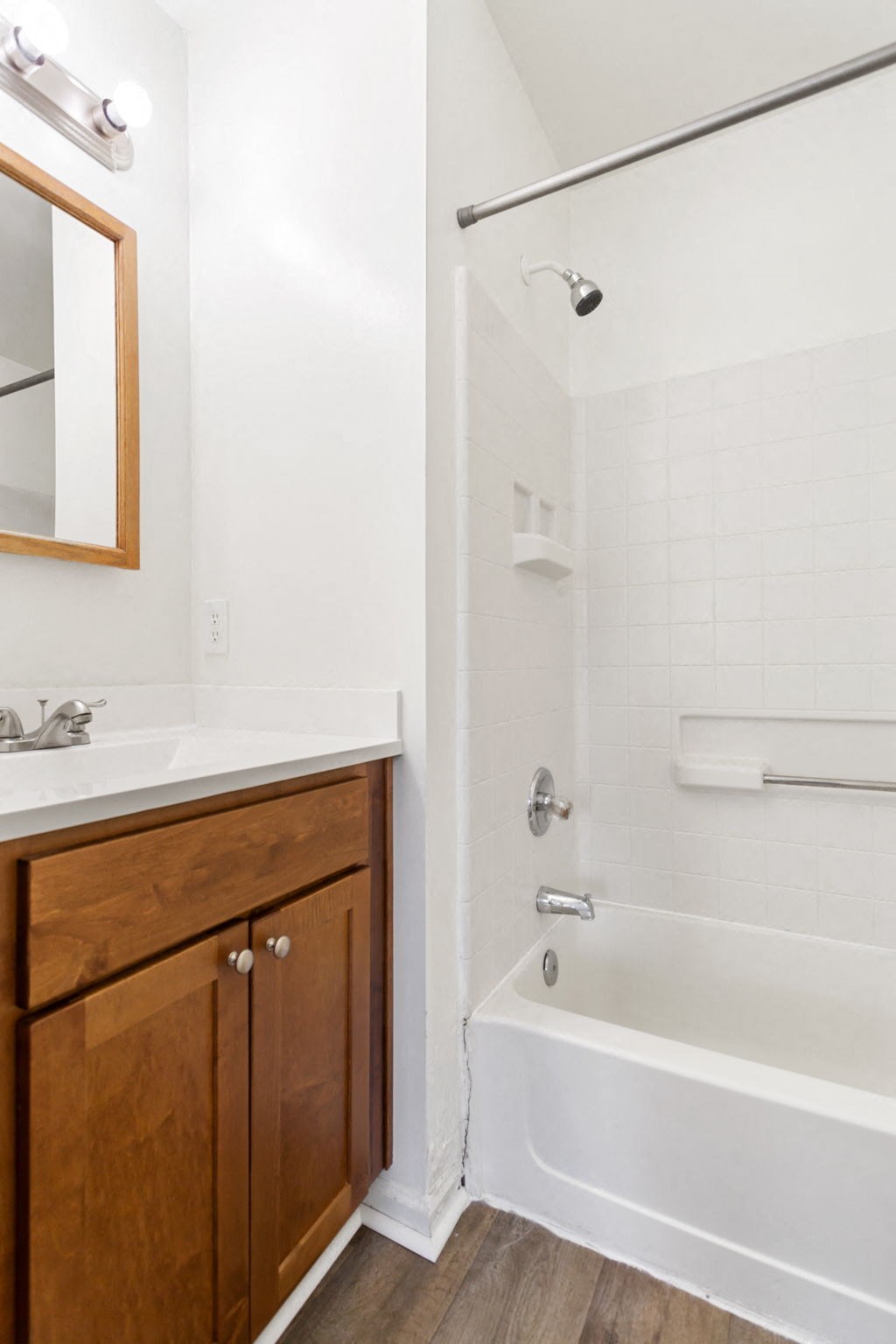 a bathroom with a white tub and a sink and a mirror
