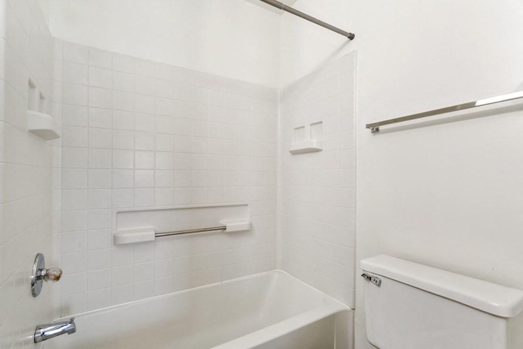 a white bathroom with a tub and a toilet