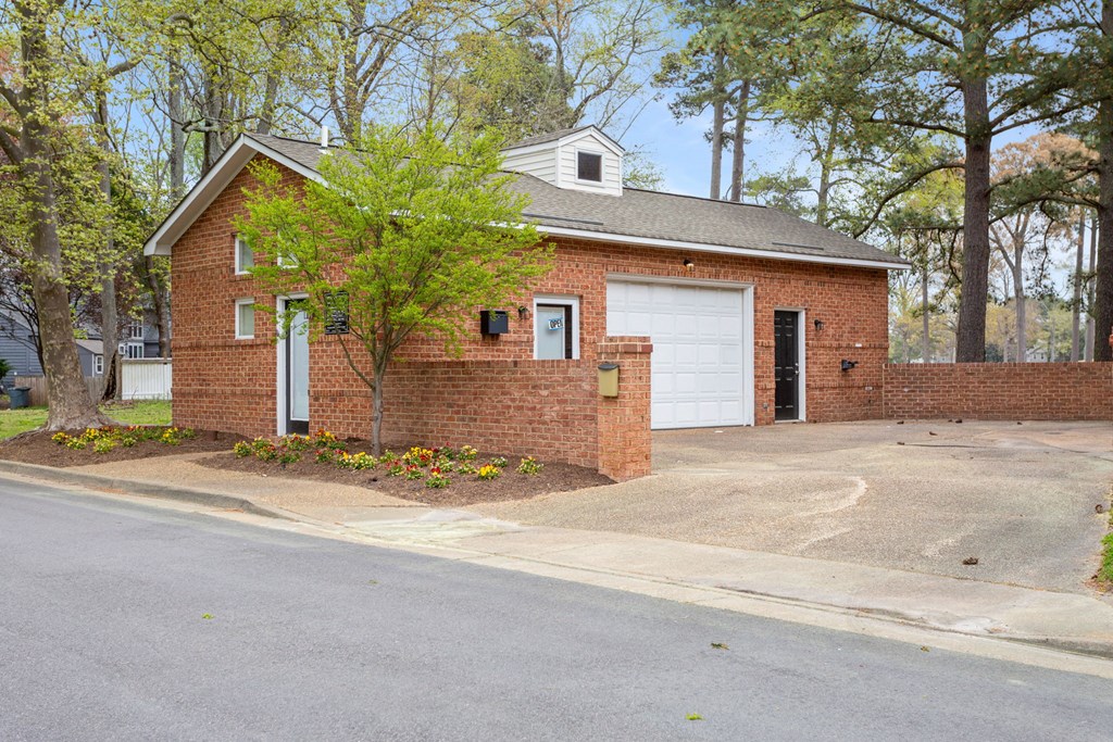 the front of a brick house with a white garage door