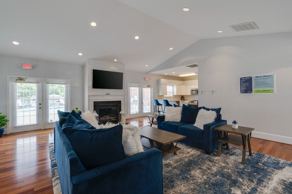 a living room with two blue couches and a fireplace