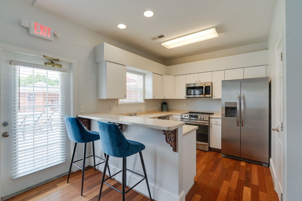 a kitchen with an island and two blue chairs