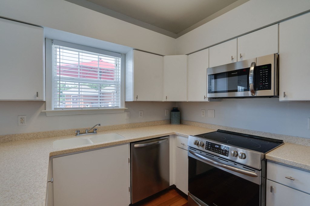 a kitchen with white cabinets and a sink and a stove